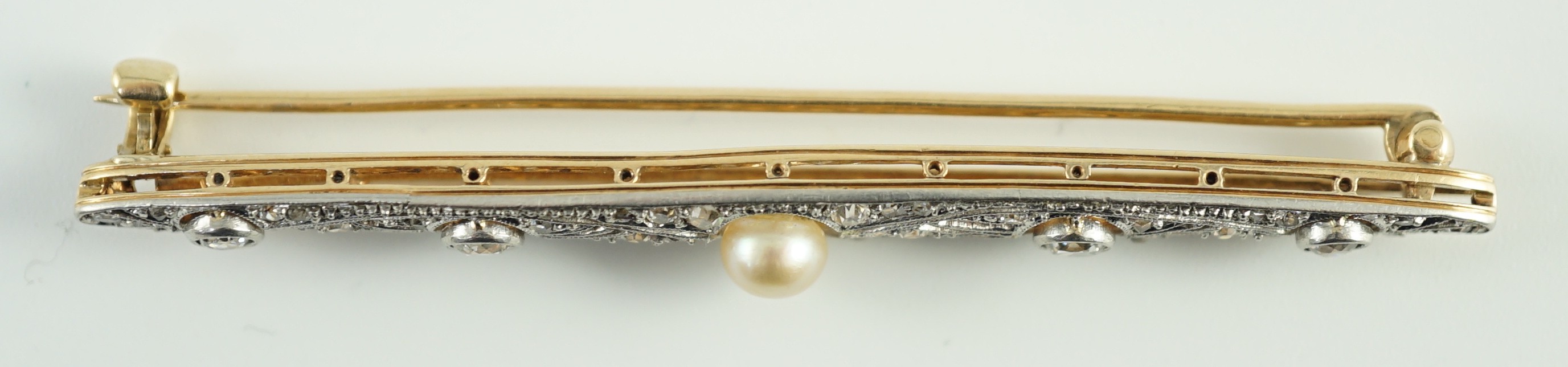 An early 20th century Belle Epoque, gold and platinum, pearl and millegrain set round and rose cut diamond navette shaped bar brooch